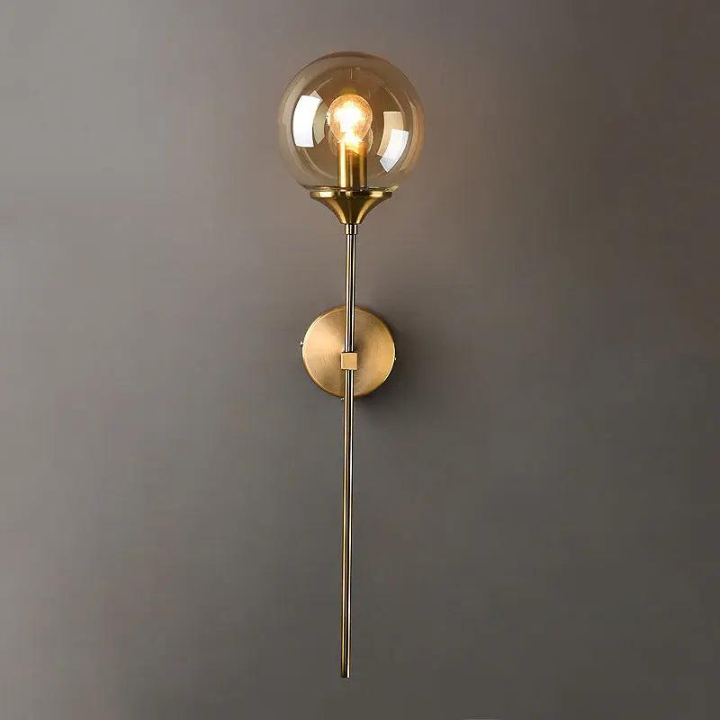 Annika amber glass ball wall sconce mounted in a dining room beside a mirror
