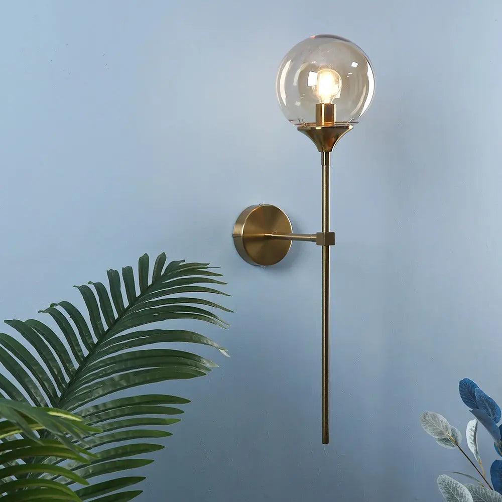 Annika amber glass ball wall sconce mounted in a dining room beside a mirror