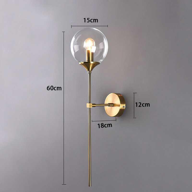 Annika amber glass ball wall sconce mounted in a dining room beside a mirror