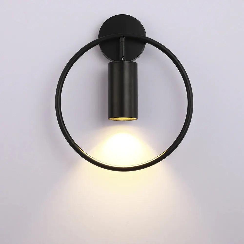 Benthe gold post-modern wall sconce on a white wall in a living room