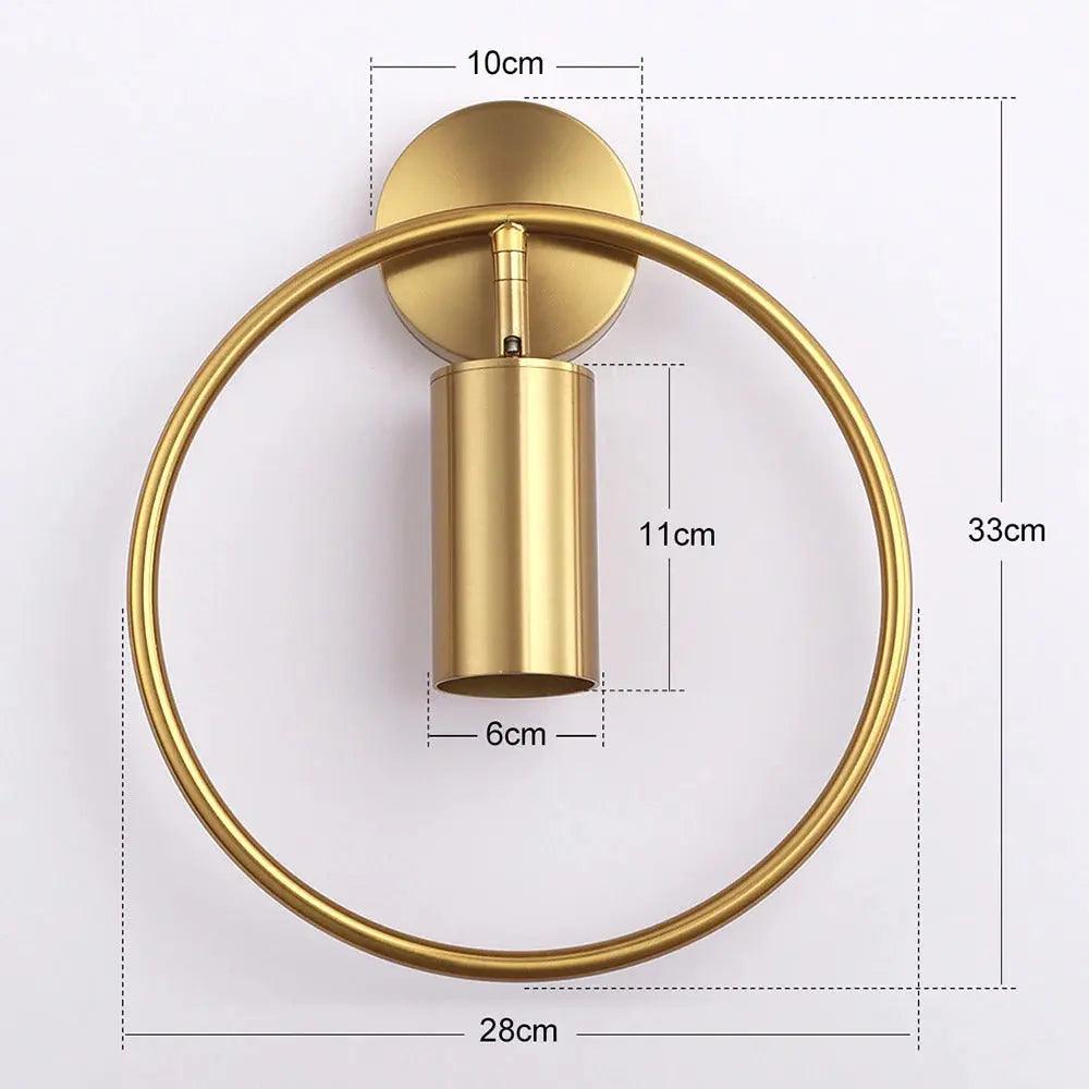 Benthe gold post-modern wall sconce on a white wall in a living room
