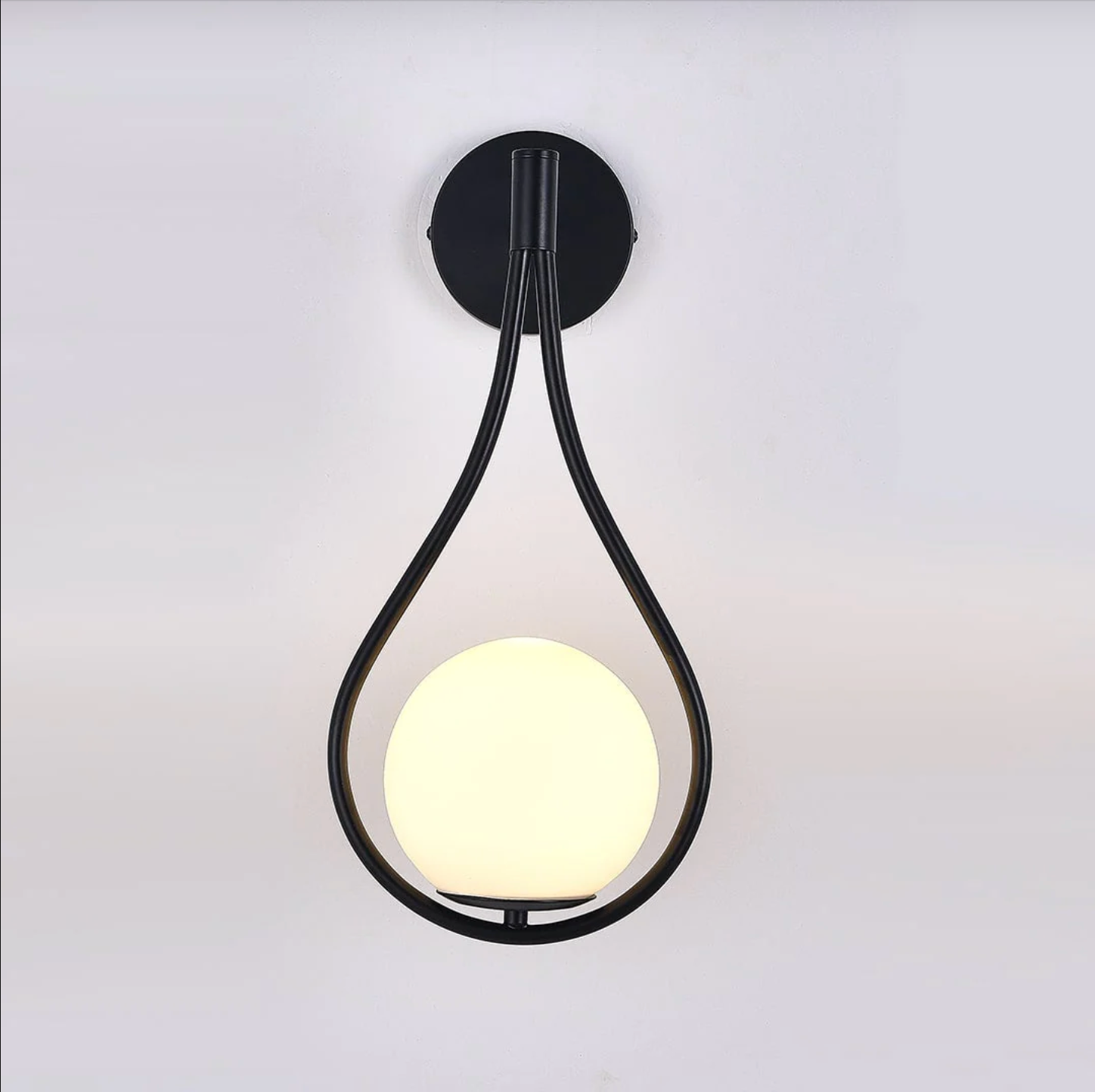 Livi gold Nordic wall sconce mounted beside a bed in a minimalist bedroom