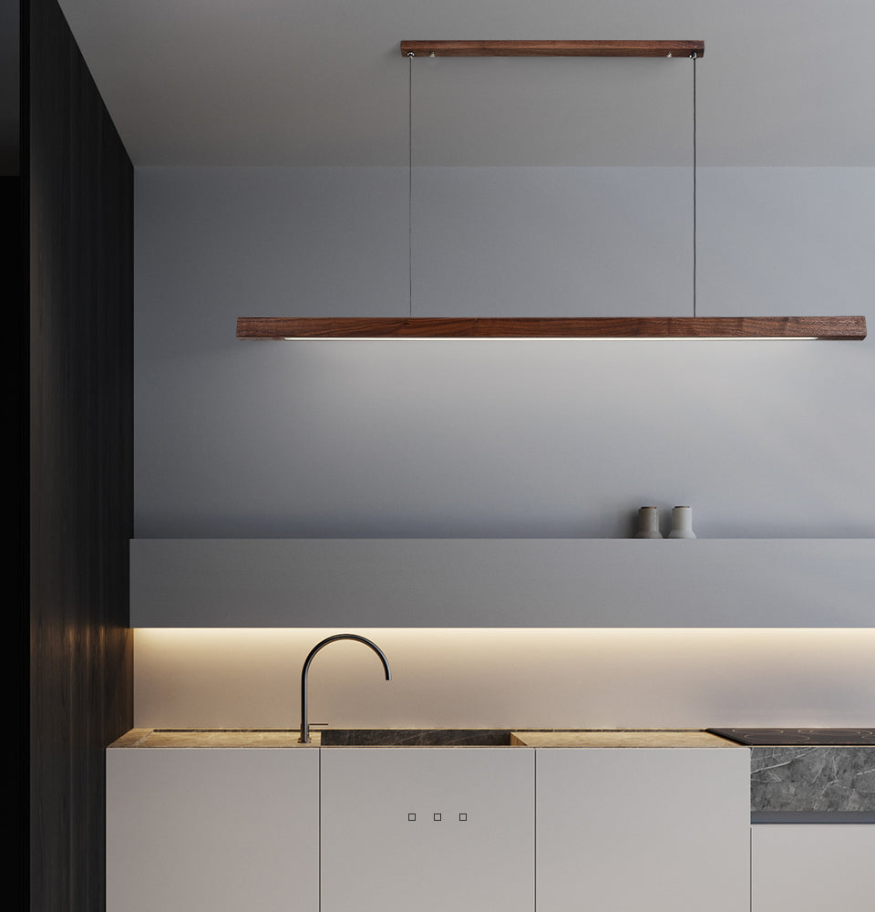 Lindö pine wood dining pendant light hanging low above a long dining table in a Nordic interior