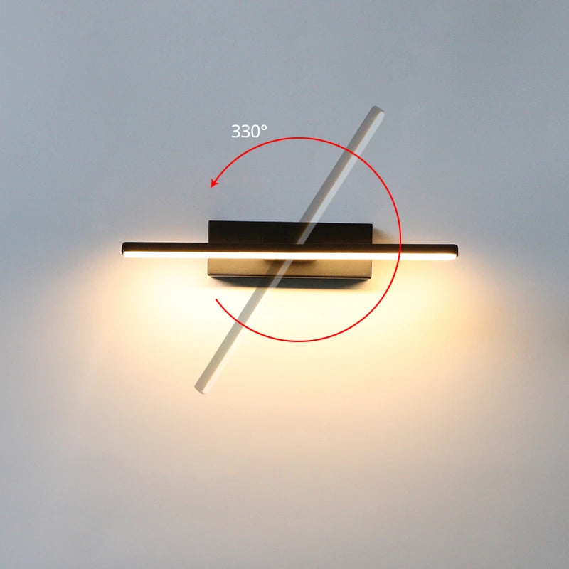 Arc 330-degree adjustable LED bedside wall lamp in black aluminium beside a bed with open book