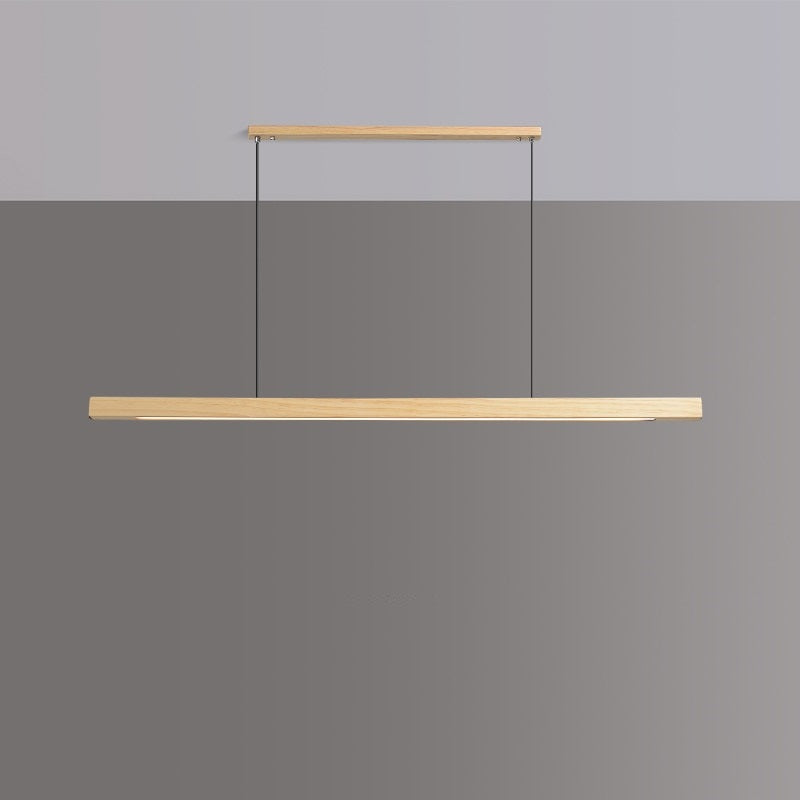 Lindö pine wood dining pendant light hanging low above a long dining table in a Nordic interior