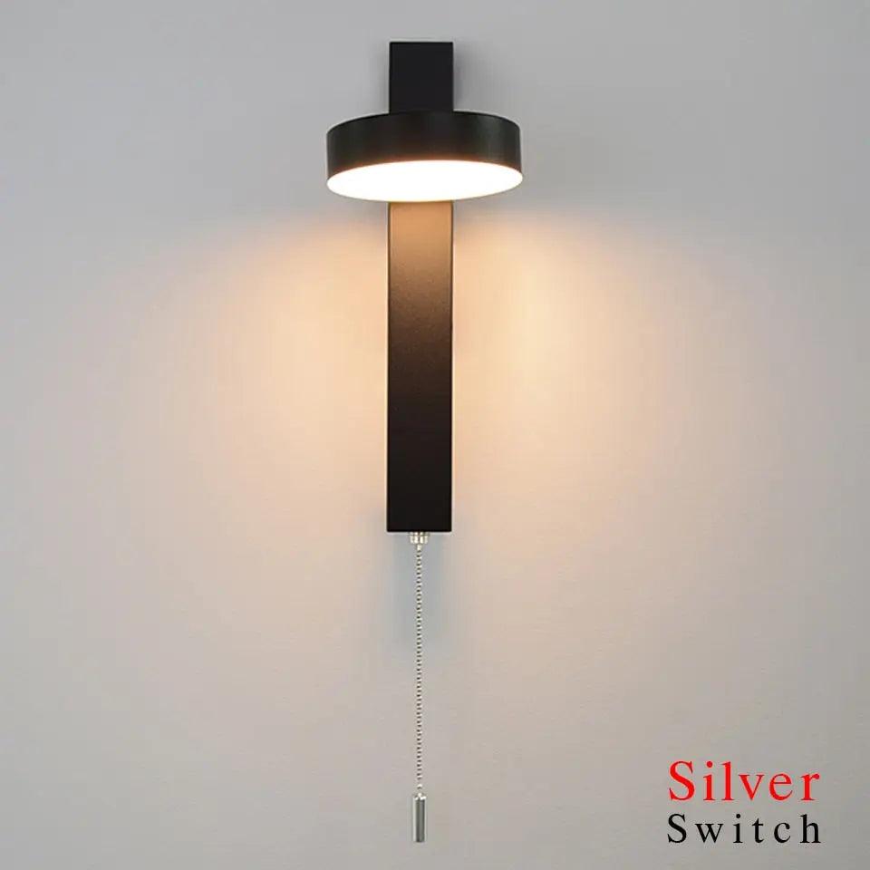 Lif gold rotating wall sconce angled upward for ambient lighting in a living room