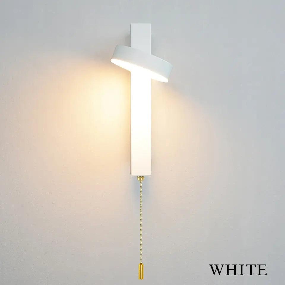 Lif gold rotating wall sconce angled upward for ambient lighting in a living room