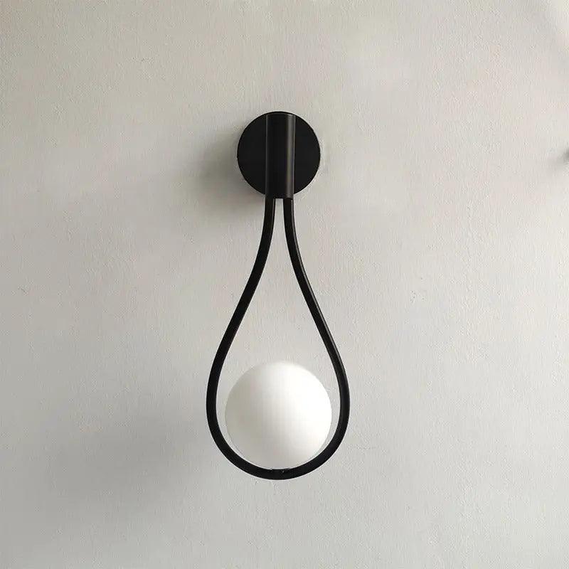 Livi II black Nordic wall sconce mounted on a dark papered wall in a hallway