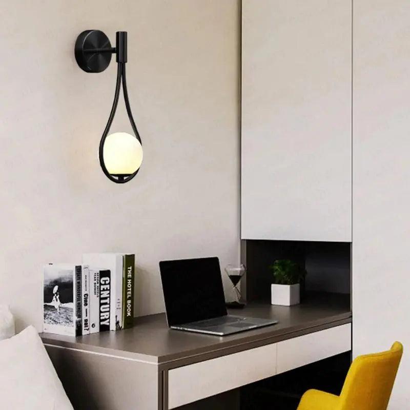 Livi II black Nordic wall sconce mounted on a dark papered wall in a hallway