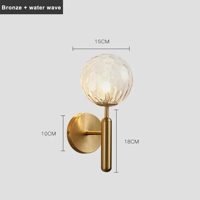 Mynte luxury gold wall sconce with marble base and milk glass shade in a bedroom
