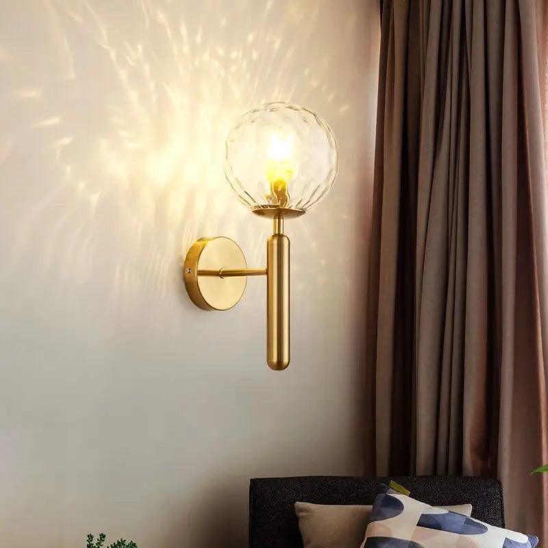 Mynte luxury gold wall sconce with marble base and milk glass shade in a bedroom
