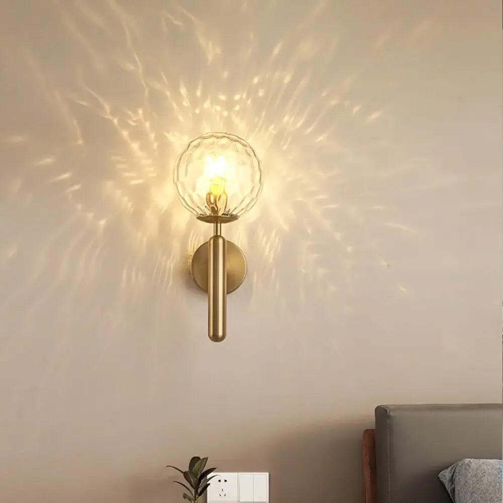 Mynte luxury gold wall sconce with marble base and milk glass shade in a bedroom