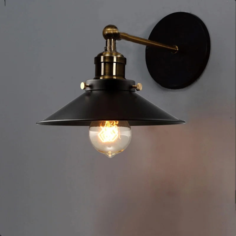 Edison industrial iron wall lamp in matte black mounted on a brick staircase wall