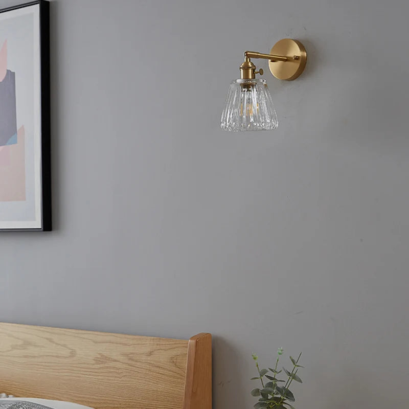 Kyoto brass and glass wall lamp mounted beside a bathroom mirror casting warm light