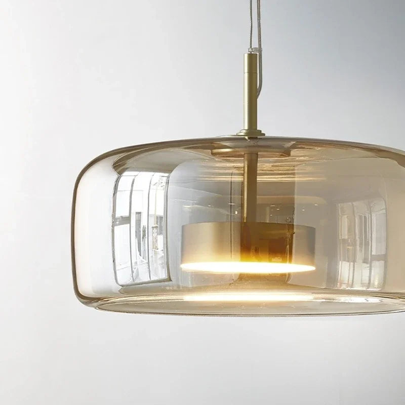 Astrid amber glass Nordic pendant light with gold fitting above a dining table