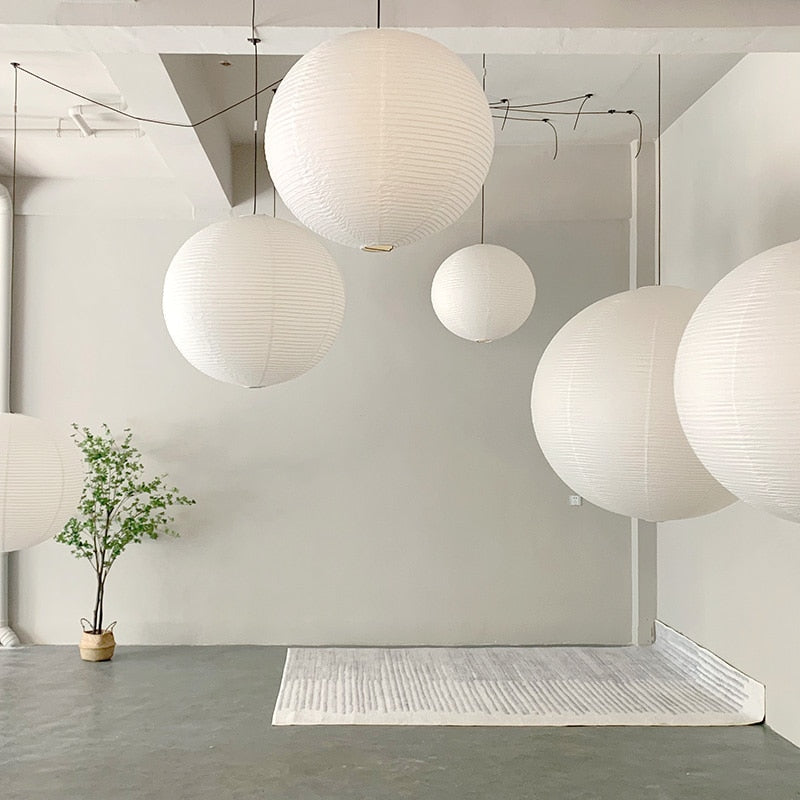 Linnea natural rattan pendant light hanging above a wooden dining table in a Nordic interior