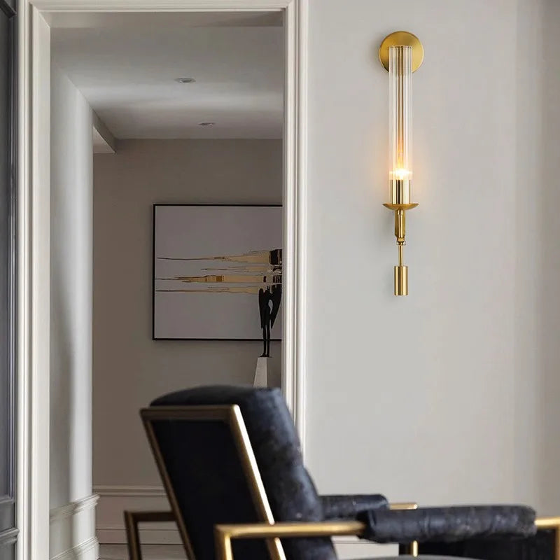 Dagny gold leaf wall sconce with glass element mounted flanking a bed