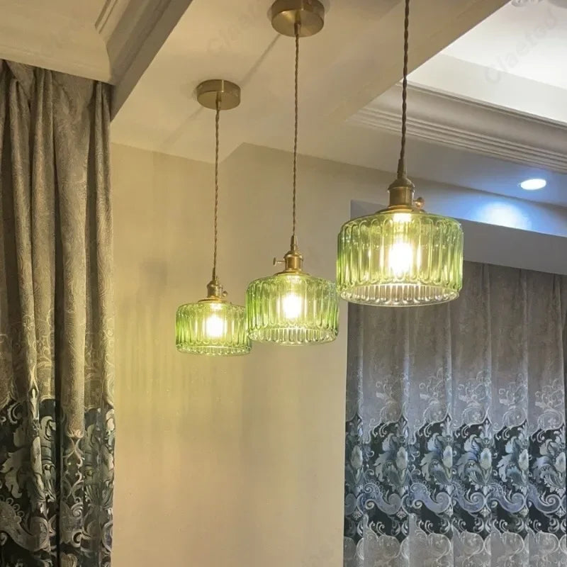 Vessel vintage glass wall lamp mounted beside a bedroom window casting warm ambient light