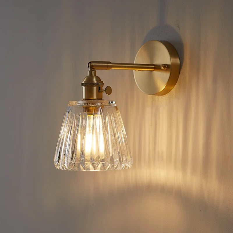 Kyoto brass and glass wall lamp mounted beside a bathroom mirror casting warm light