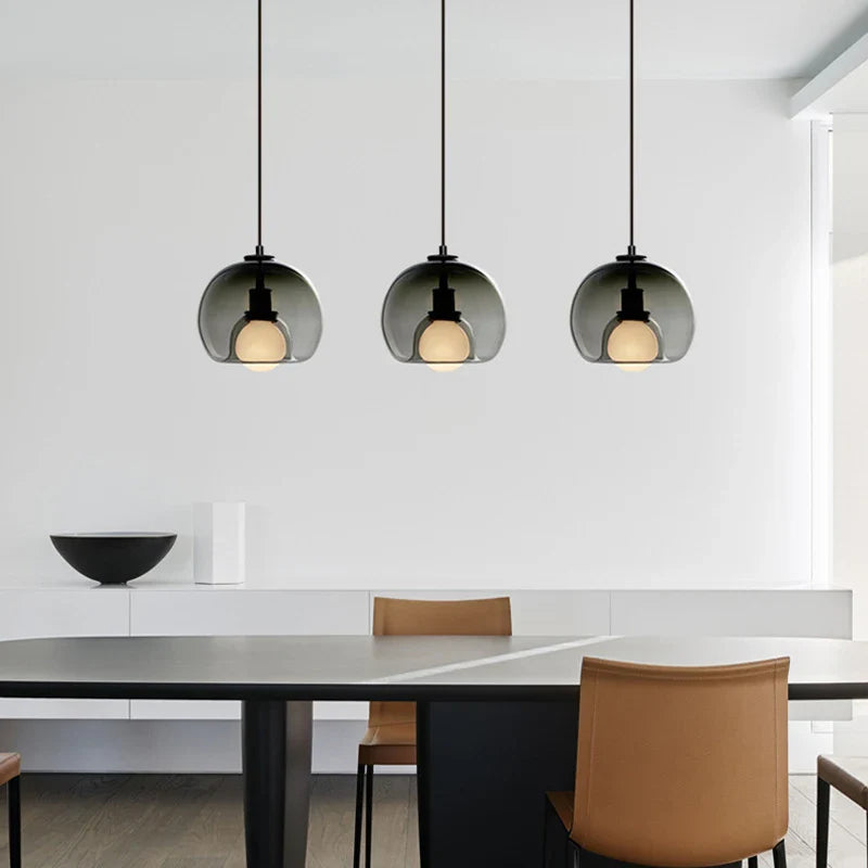 Anele smoke grey dome glass pendant light in a row of three above a kitchen island