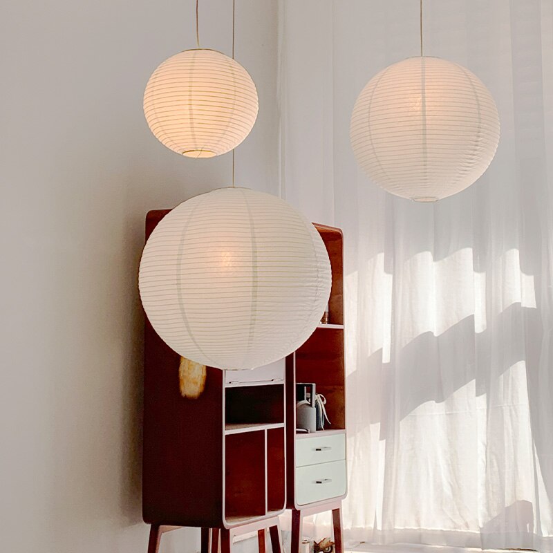 Linnea natural rattan pendant light hanging above a wooden dining table in a Nordic interior