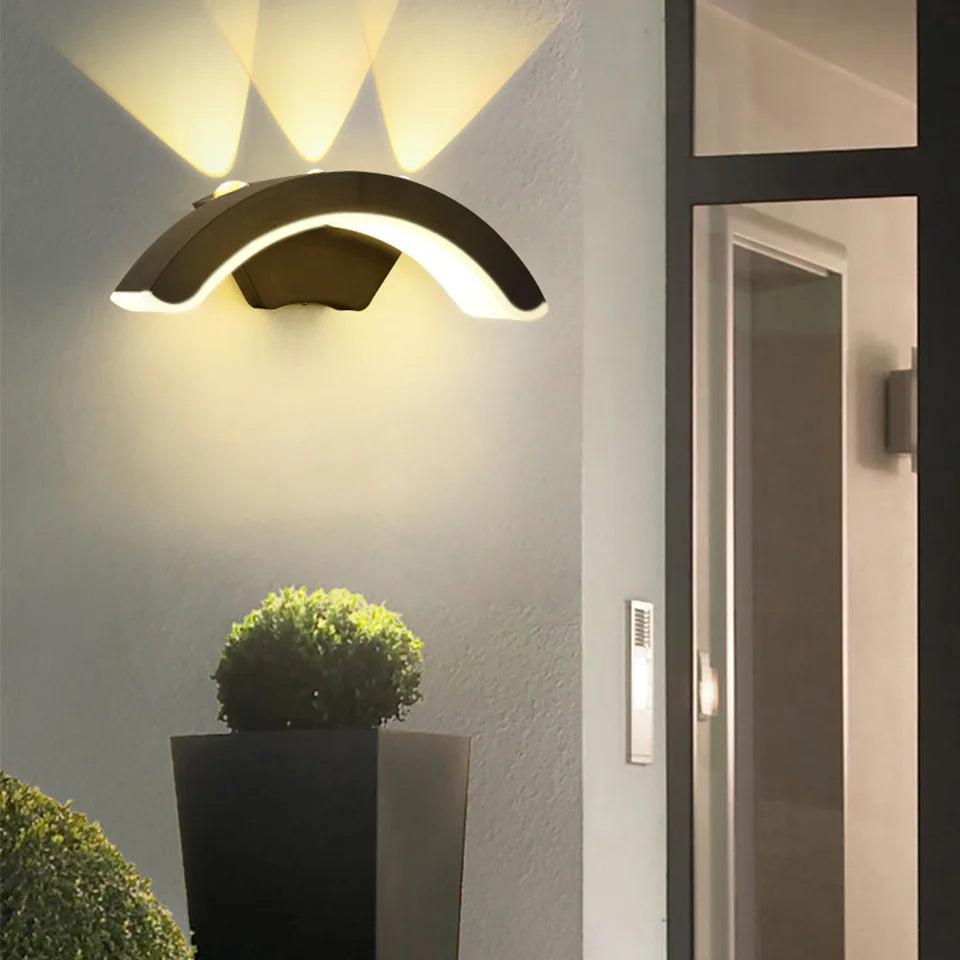 Hadley IP66 weatherproof outdoor wall lantern in black, mounted on a rendered exterior wall