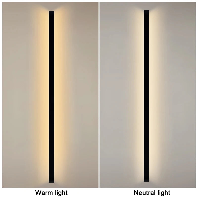 Croft linear LED wall sconce mounted vertically beside a bedroom headboard, casting a warm wash of light