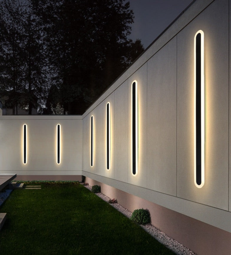 Cupola IP65 wrought iron outdoor wall light mounted on a rendered garden wall at dusk