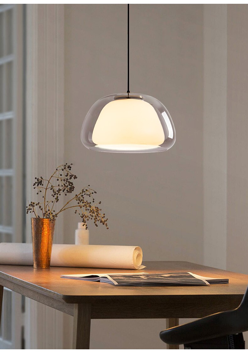 Amba clear jelly globe pendant light with gold fitting hanging above a dining table