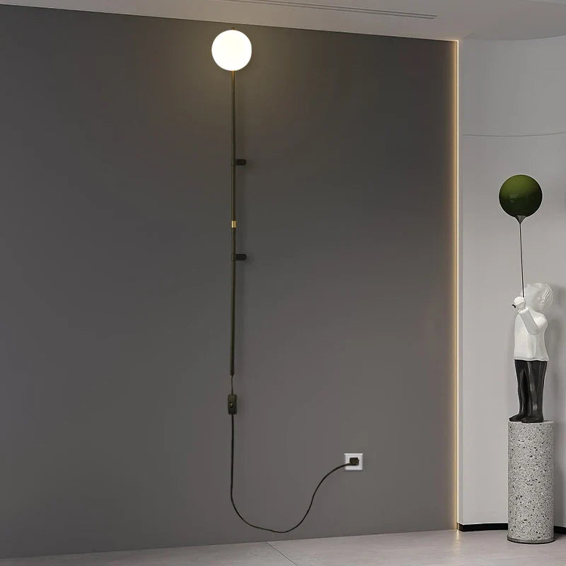 Sol Nordic plug-in wall sconce in black mounted in a living room beside a sofa
