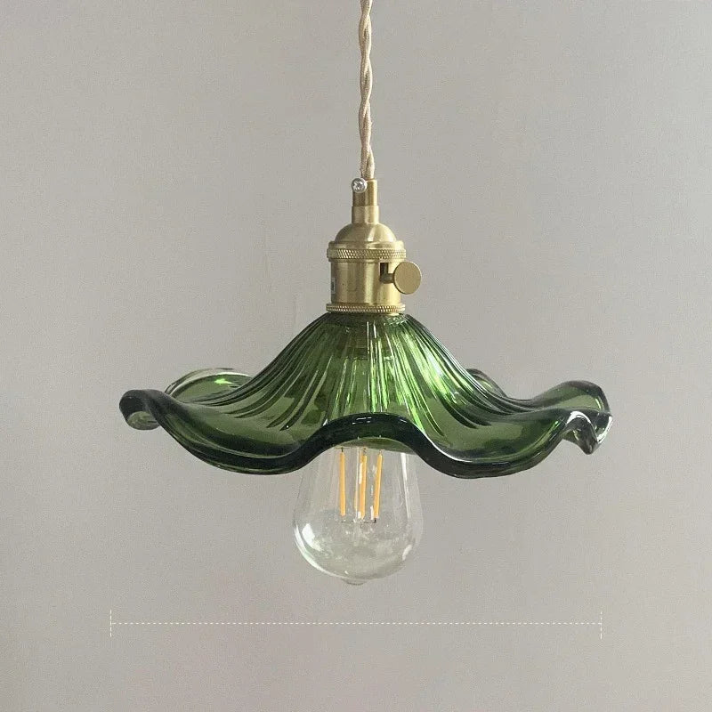 Prism green glass pendant light with copper fitting hanging in a dining room