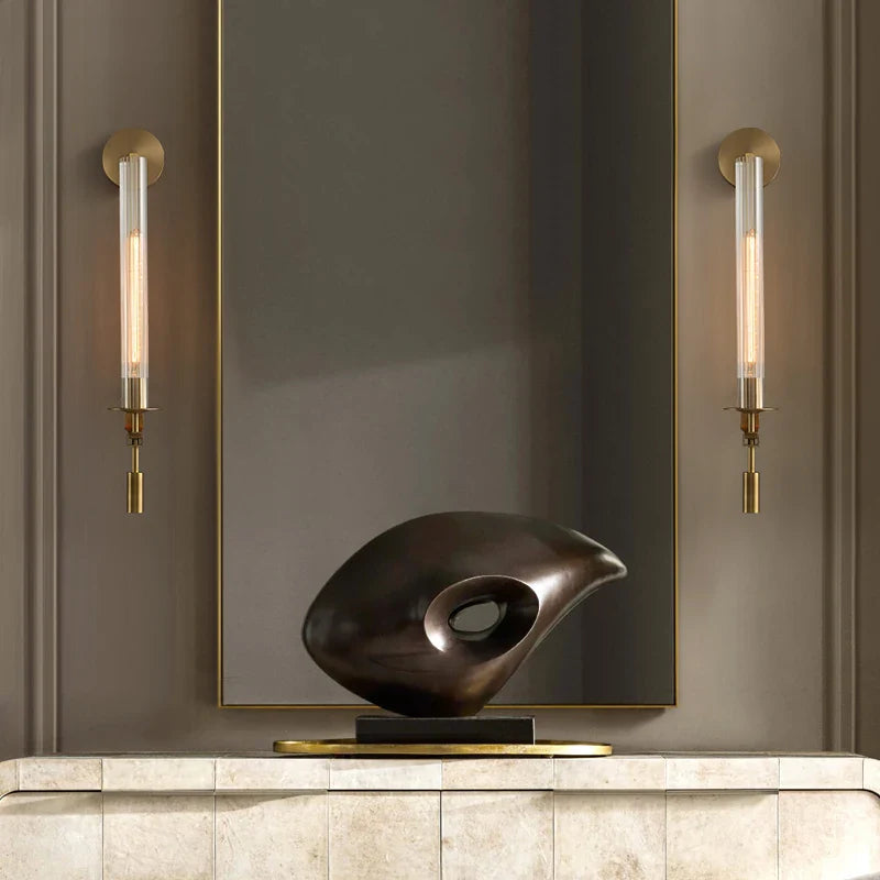 Dagny gold leaf wall sconce with glass element mounted flanking a bed