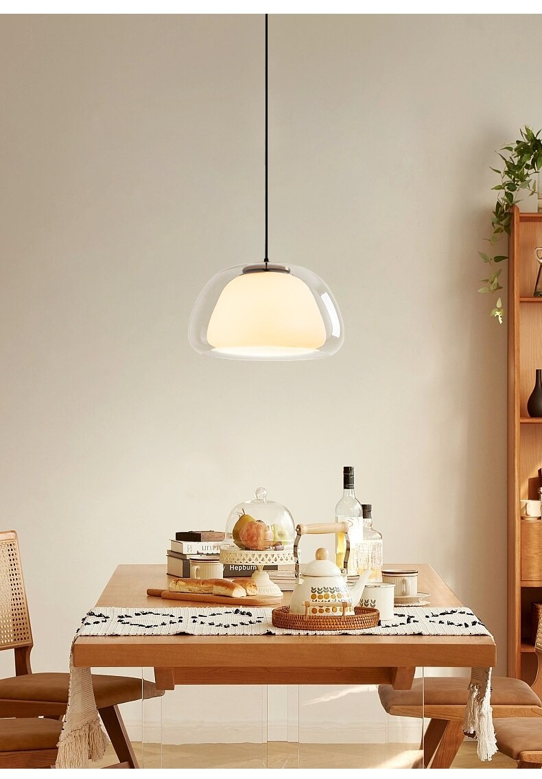 Amba clear jelly globe pendant light with gold fitting hanging above a dining table