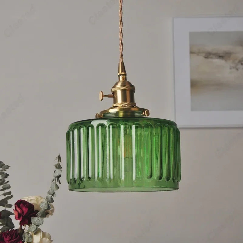 Vessel vintage glass wall lamp mounted beside a bedroom window casting warm ambient light