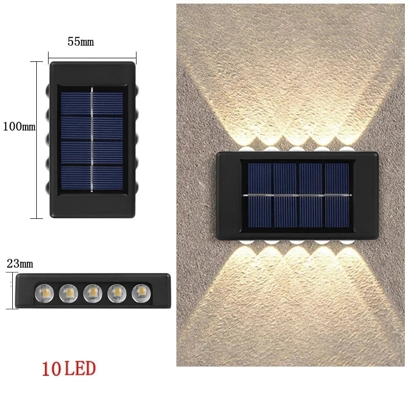 Solstice solar wall light mounted on a garden fence, illuminated at dusk