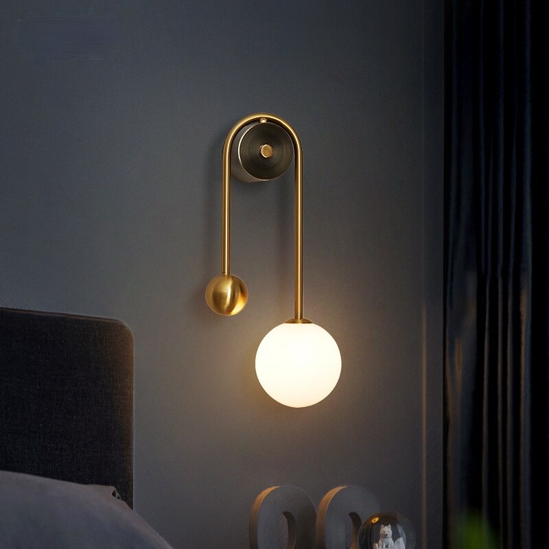 Amalia twin-arm gold Nordic wall sconce with white glass shades flanking a dining room mirror