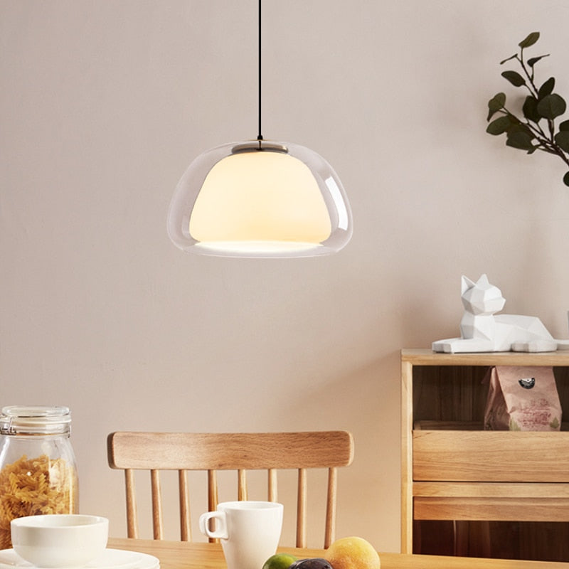 Amba clear jelly globe pendant light with gold fitting hanging above a dining table