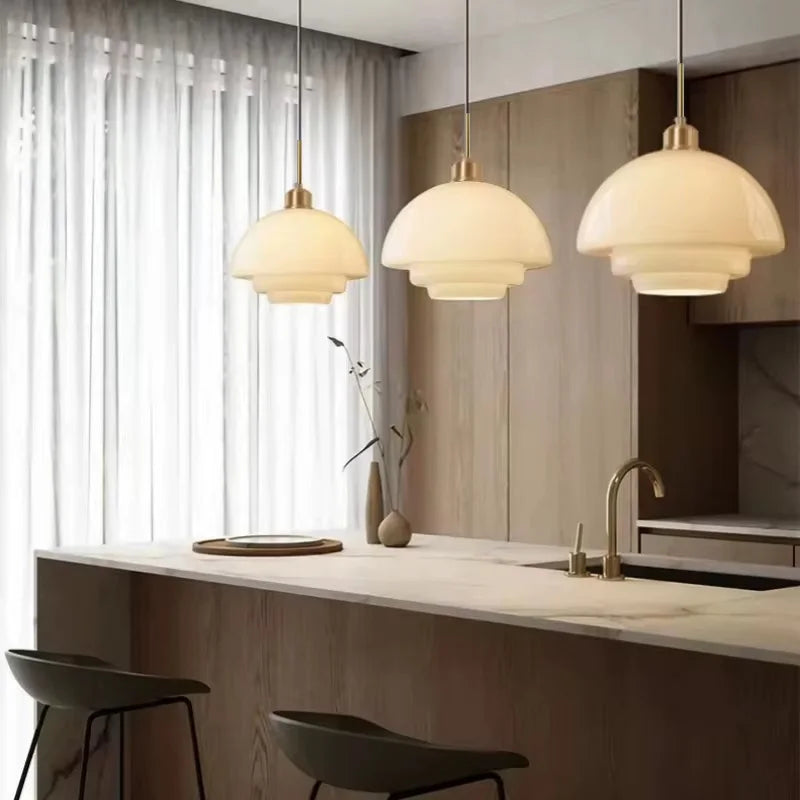 Opal milk glass pendant light hanging above a dining table, casting a soft warm glow