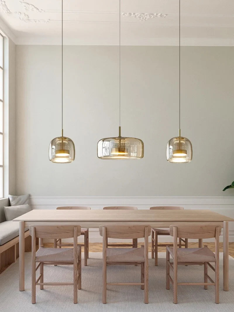 Astrid amber glass Nordic pendant light with gold fitting above a dining table