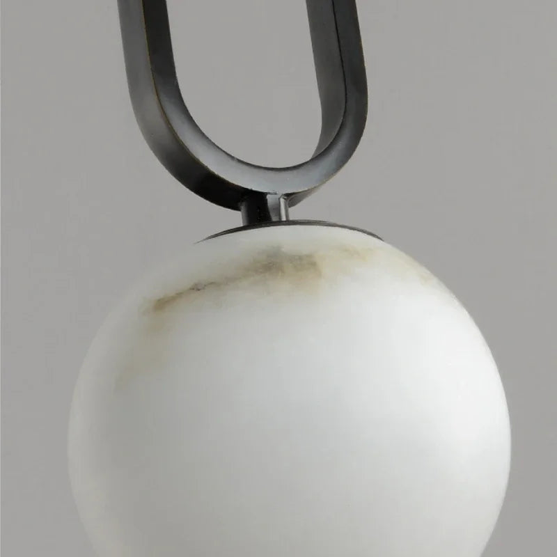 Hulda natural marble pendant light with copper accents above a formal dining table