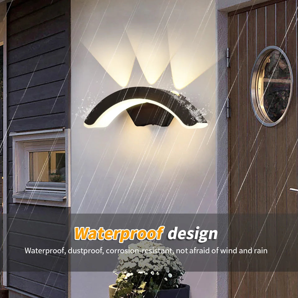 Hadley IP66 weatherproof outdoor wall lantern in black, mounted on a rendered exterior wall