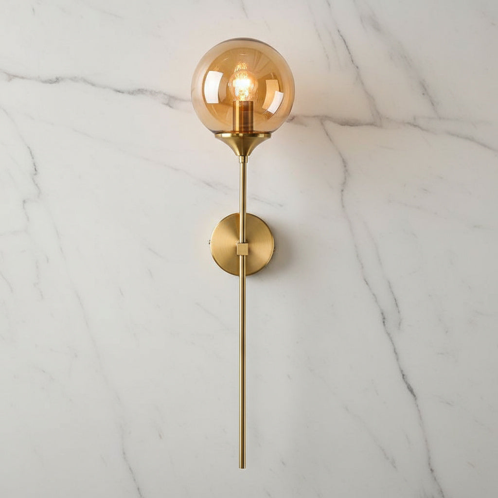 Annika amber glass ball wall sconce mounted in a dining room beside a mirror
