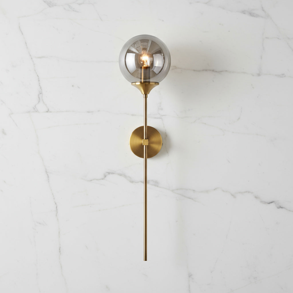 Annika amber glass ball wall sconce mounted in a dining room beside a mirror