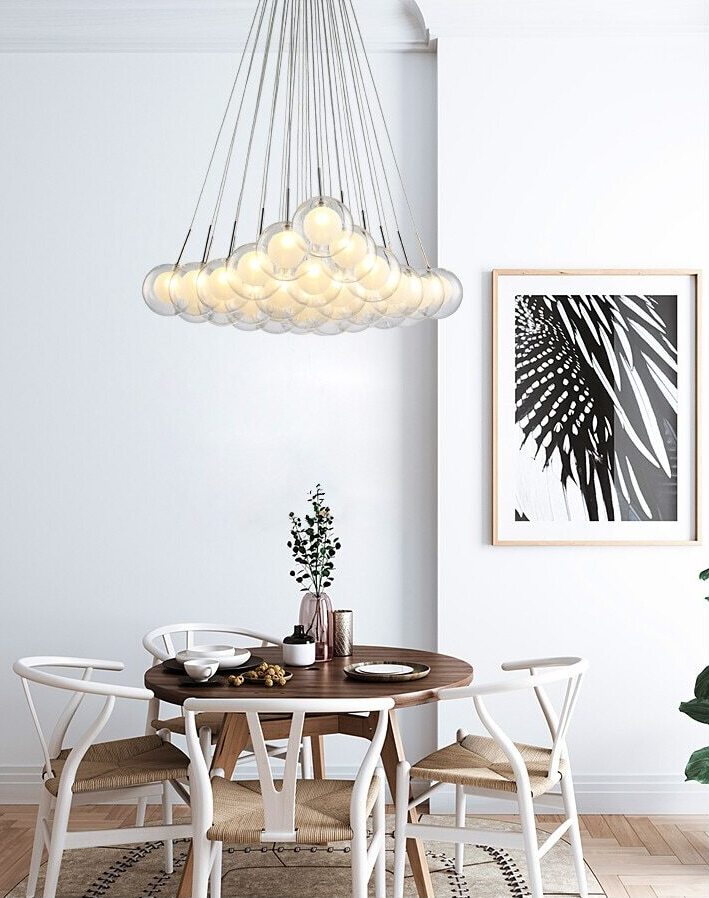 Cluster glass ball chandelier with multiple white glass spheres hanging above a dining table