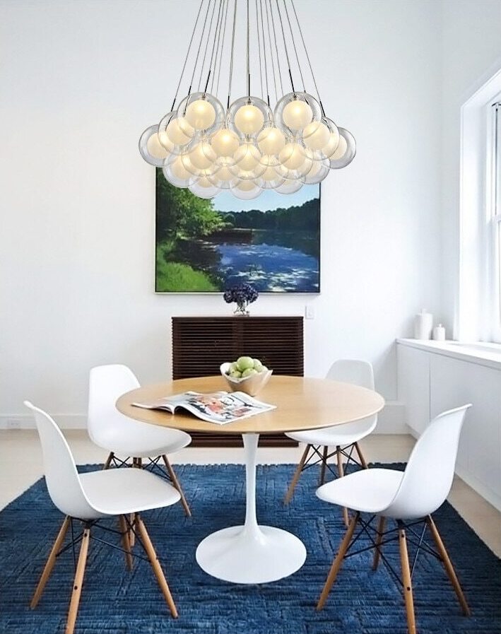 Cluster glass ball chandelier with multiple white glass spheres hanging above a dining table