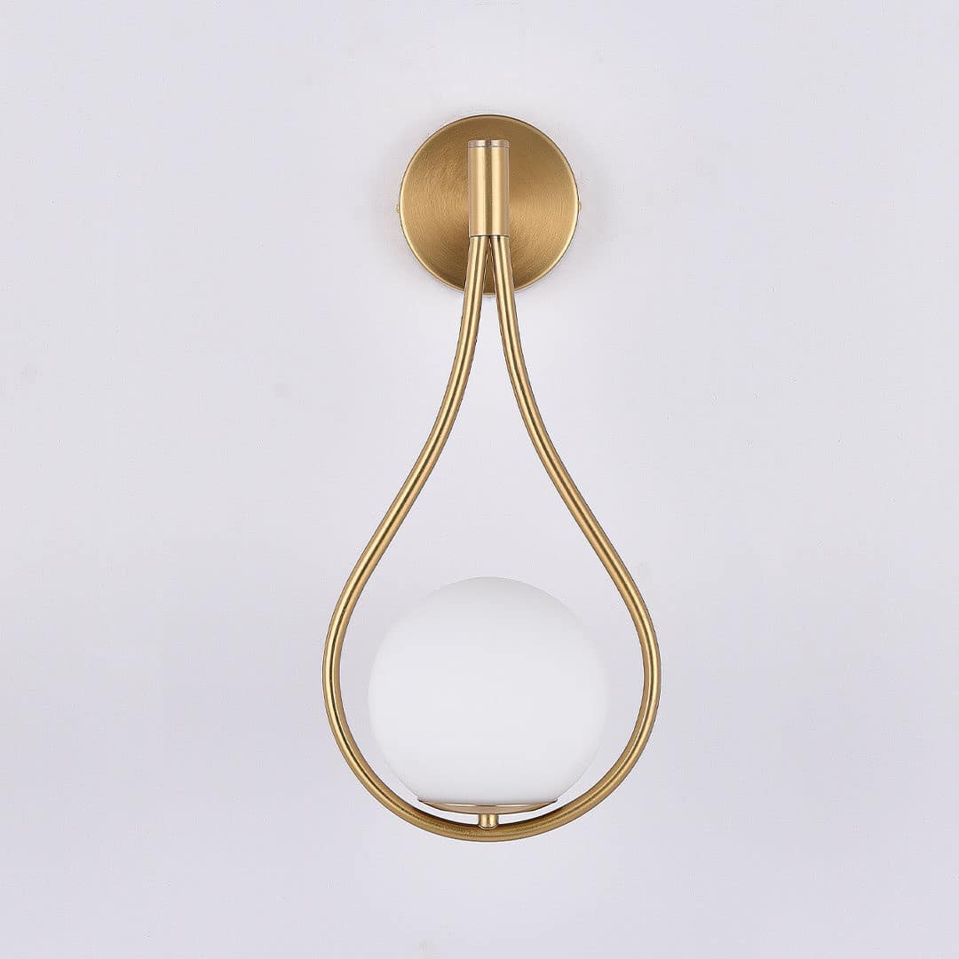Livi gold Nordic wall sconce mounted beside a bed in a minimalist bedroom