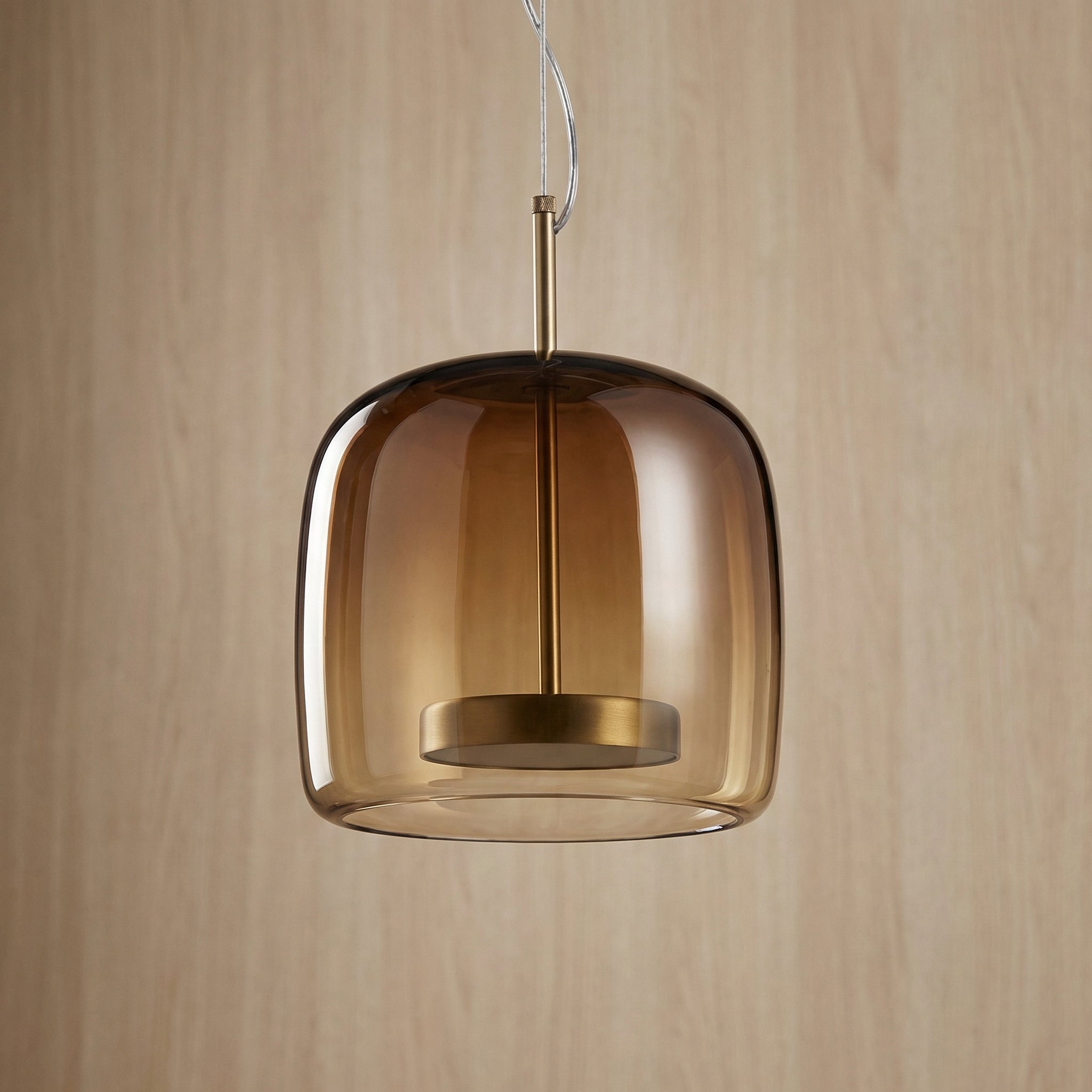 Astrid amber glass Nordic pendant light with gold fitting above a dining table