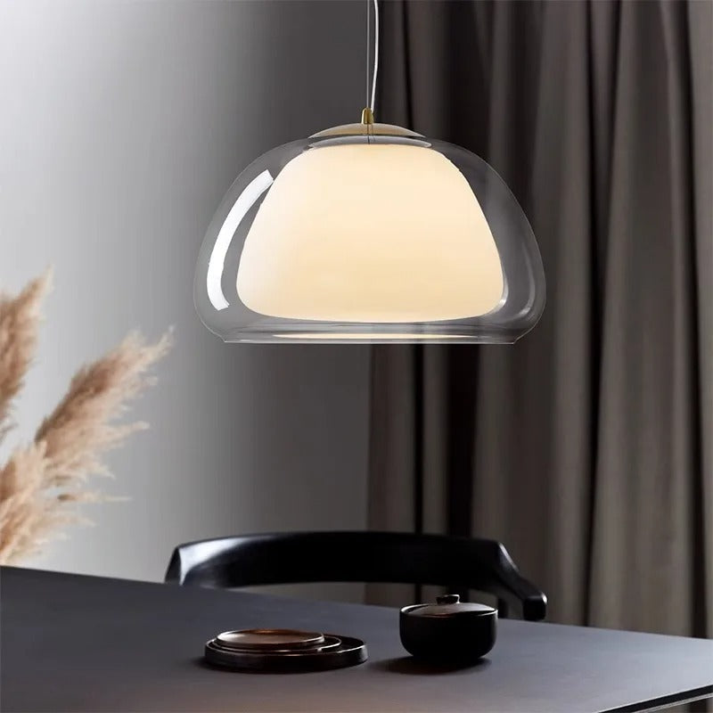 Amba clear jelly globe pendant light with gold fitting hanging above a dining table