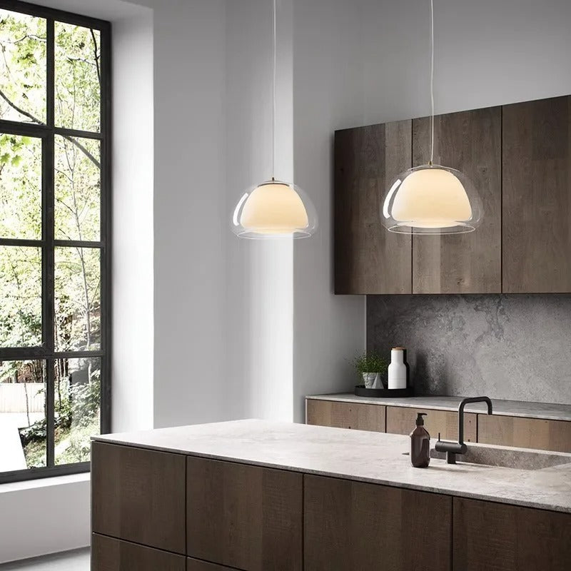 Amba clear jelly globe pendant light with gold fitting hanging above a dining table