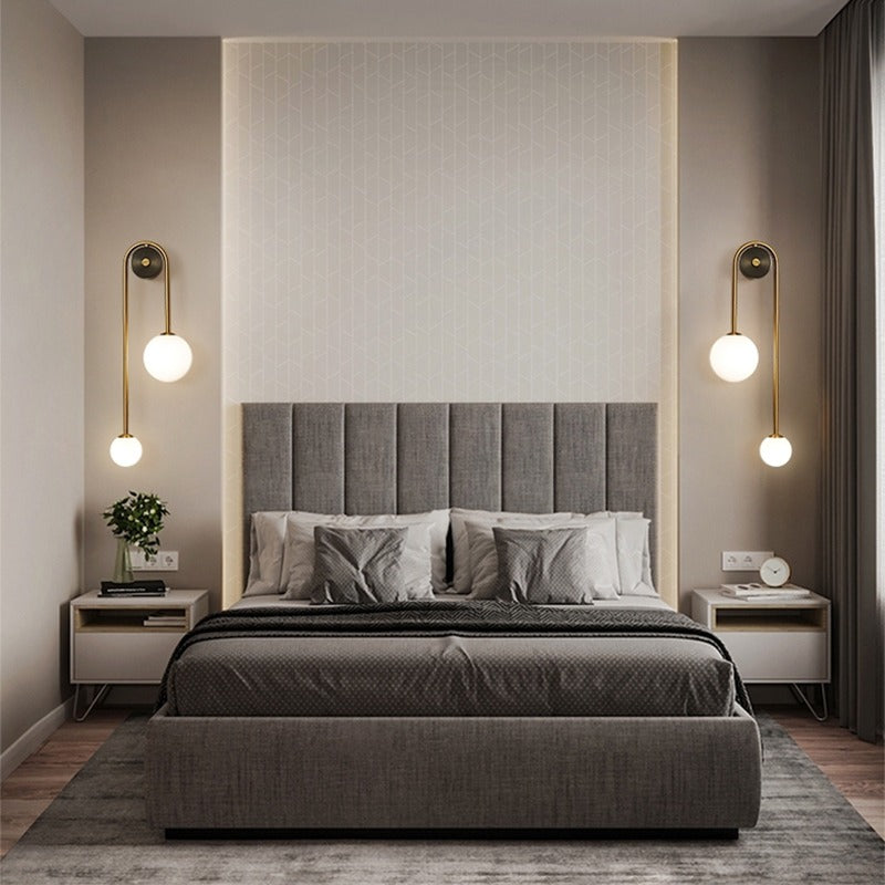 Amalia twin-arm gold Nordic wall sconce with white glass shades flanking a dining room mirror